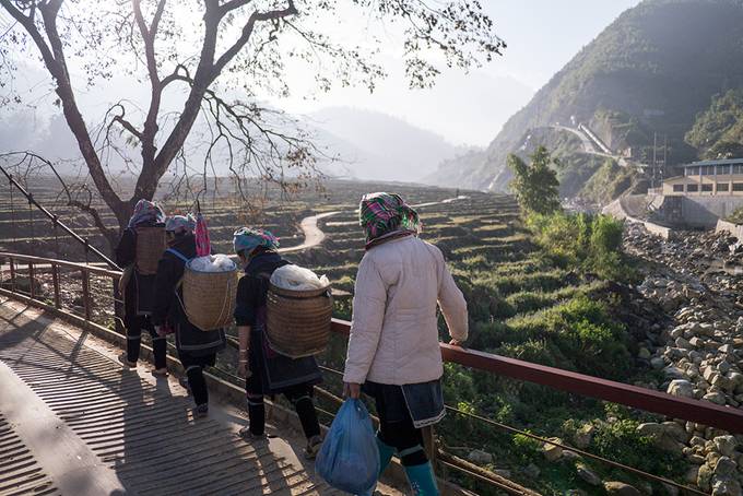 Hmong villagers crossing a bridge