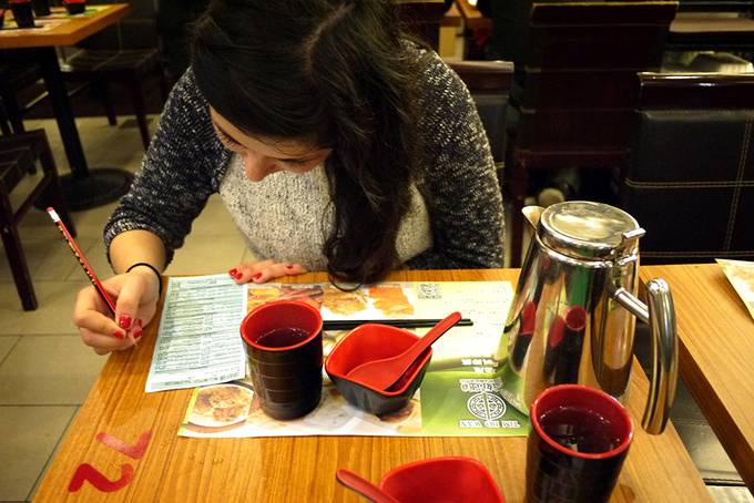 girl filling out dim sum order sheet