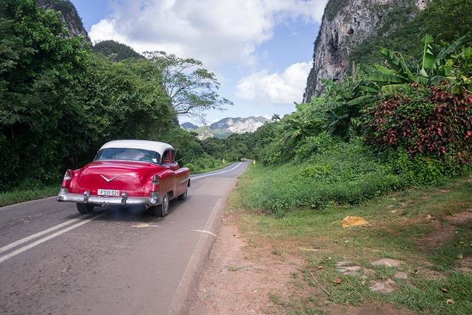 A classic car driving in the countryside